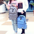 A male holding the blue anti-theft backpack standing next to a women holding the grey secure backpack.